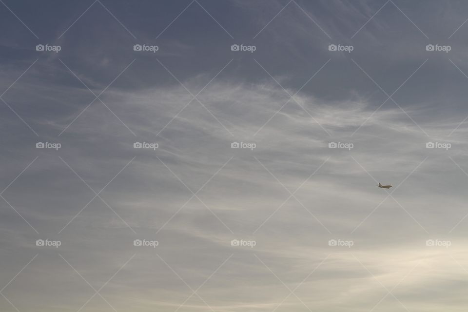 morning sky and a airplane flying up in the distance