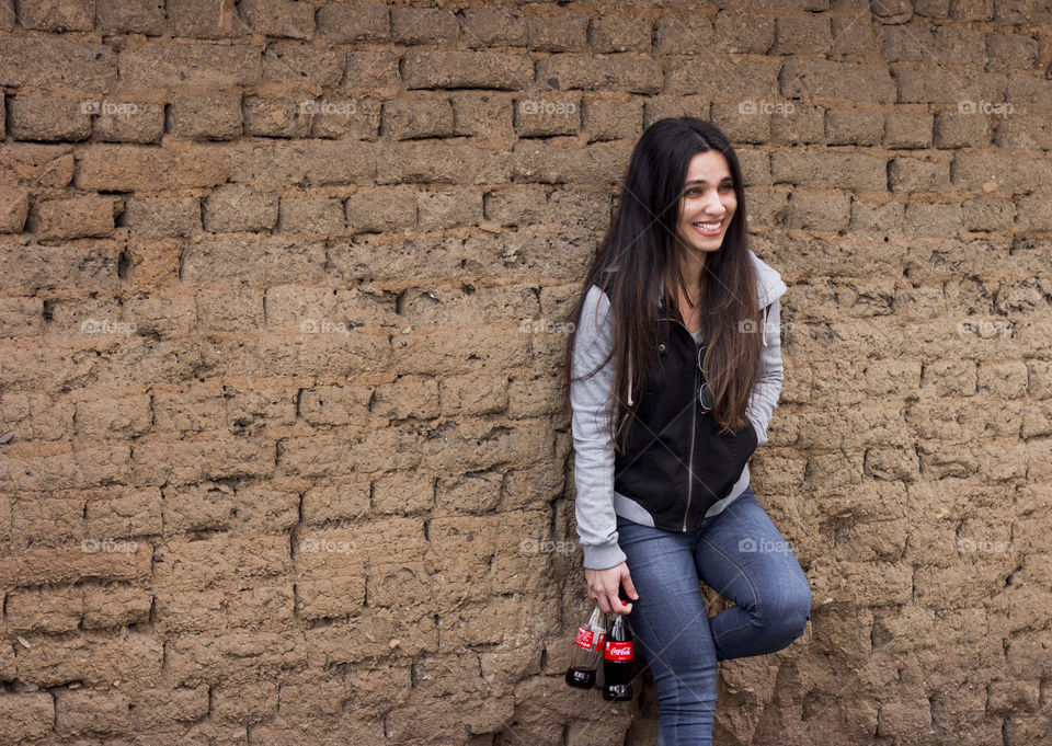 Beautiful young woman holding Coca Cola bottles