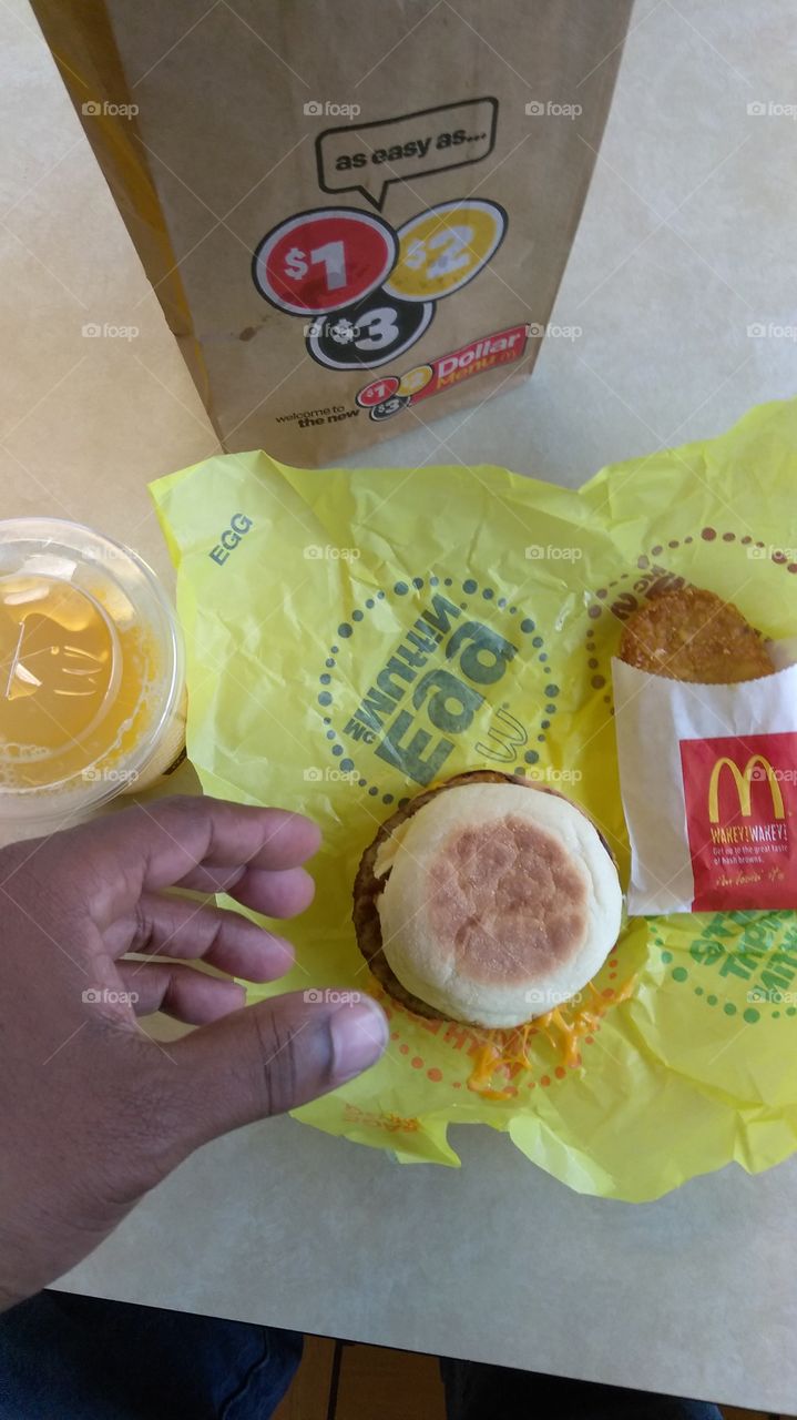 morning breakfast, sausage egg McMuffin, hash brown, orange juice. Flat lay