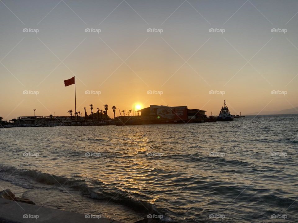 Beach time on holidays. Blue sky and tall palm trees. Sunsets and sunny days. Summertime in Kusadasi. Vacation travel in Turkey . Summer view. Sunny day during vacation 