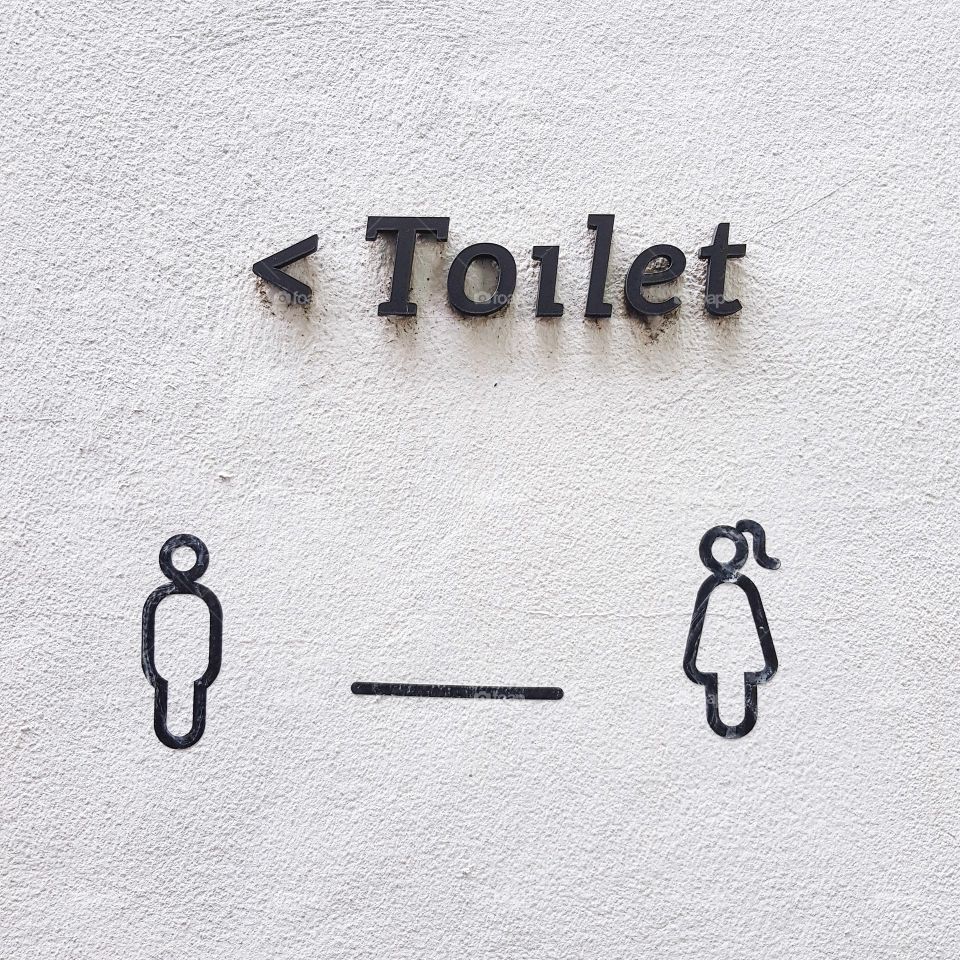 Toilet sign on concrete wall