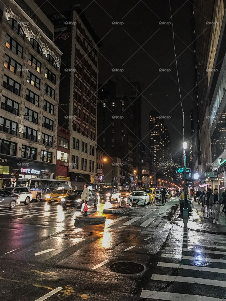 New York City at night, people walking, traffic trough the city, tourist enjoying the beauty of this city