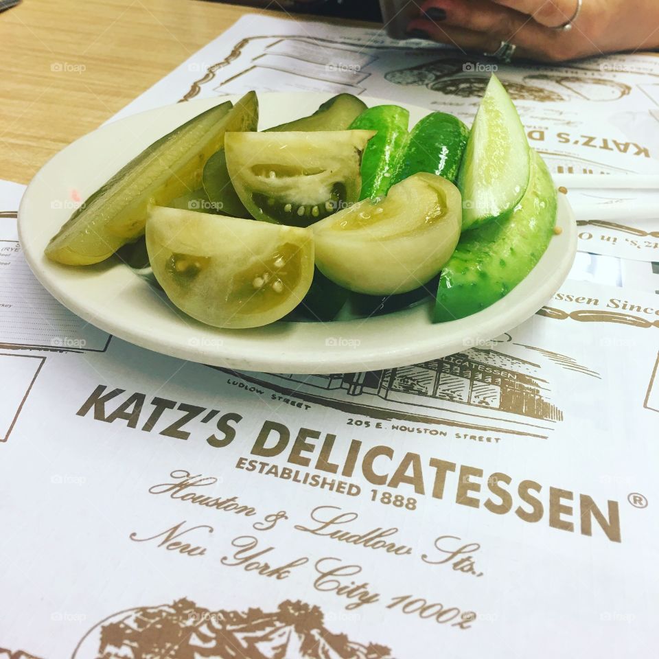 Plate of green tomatoes and pickles served at Katz's Delicatessen in New York City.