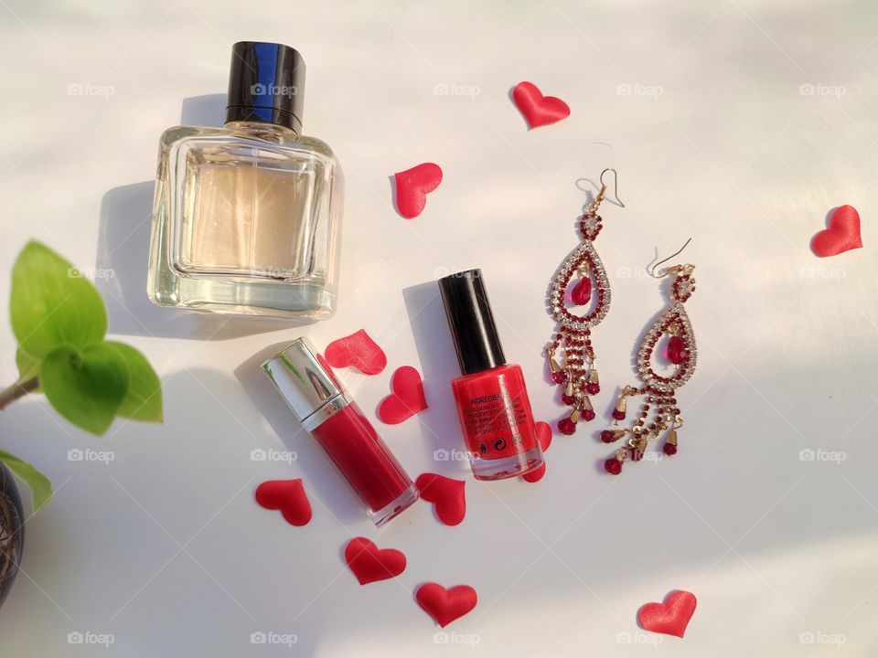 Double earings with some cosmetic products on white background