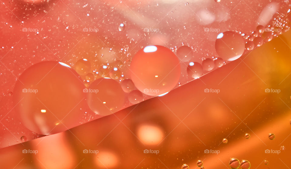 Orange oil bubbles on the water surface