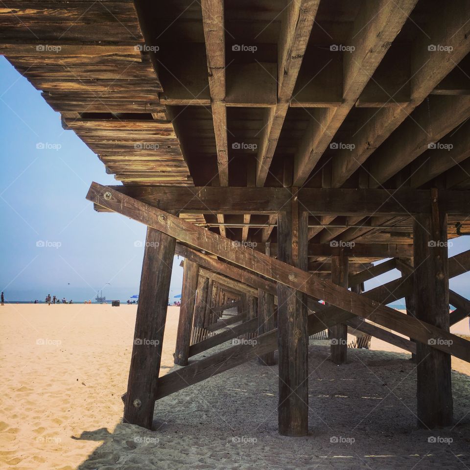 Under view of wooden jetty at beach