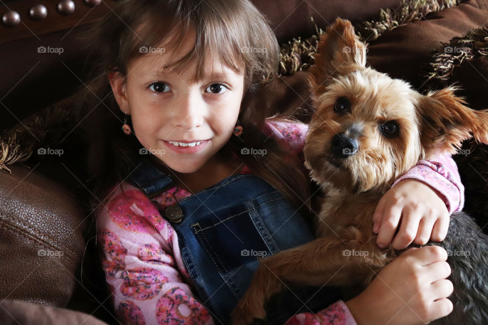 Little girl cuddling her dog