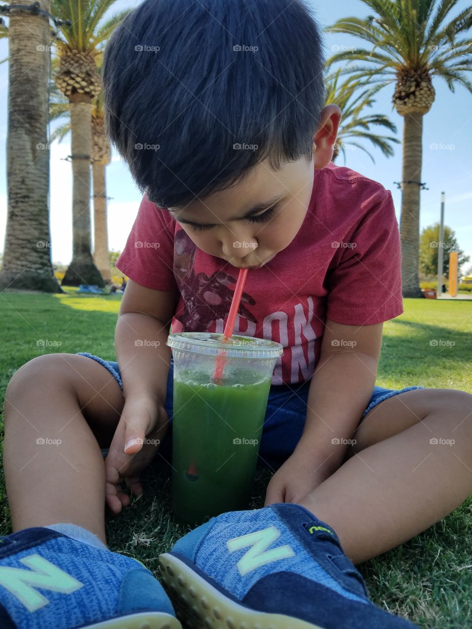 drinking green juice at the park