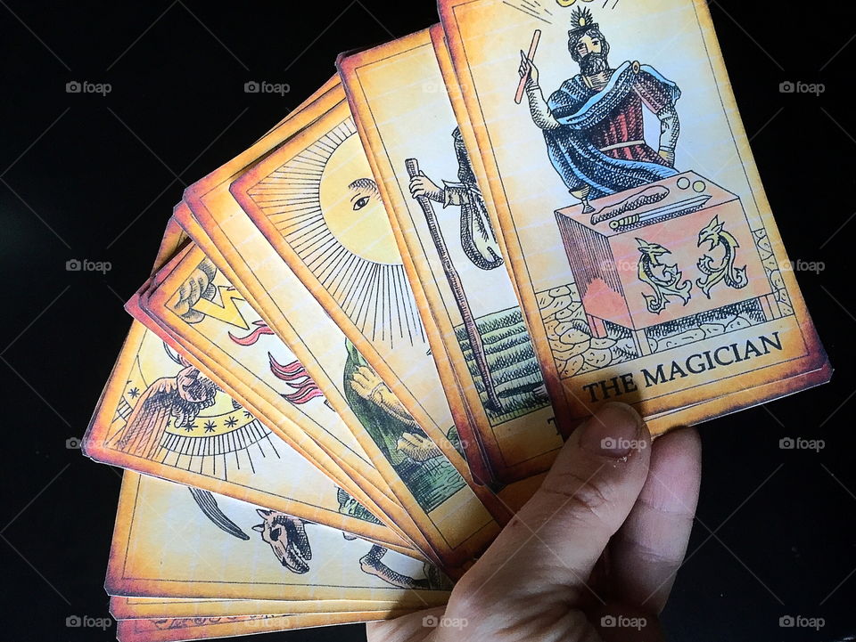 A person holding Tarot cards