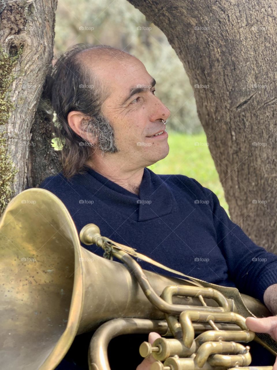 Portrait of Ricardo, relaxing under a tree with his tuba