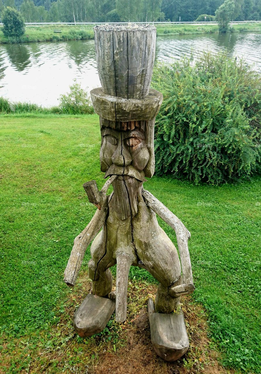 a wooden man by the river