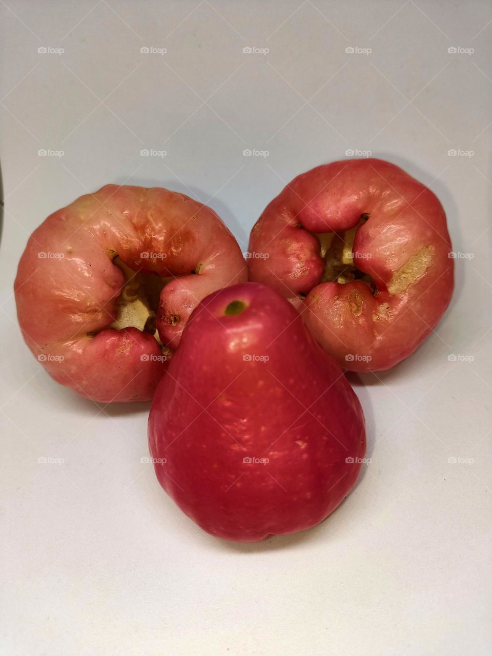 Close up of wax apple isolated on white background. Selective focus, underexposed, blurry, low light, too soft