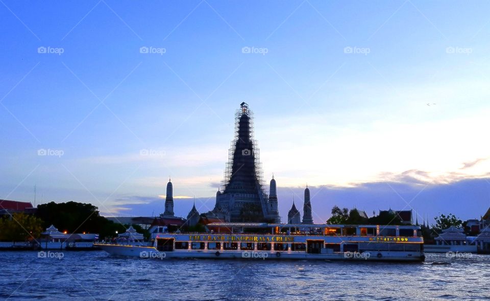 Bangkok at dusk. A boat cruising on the river.