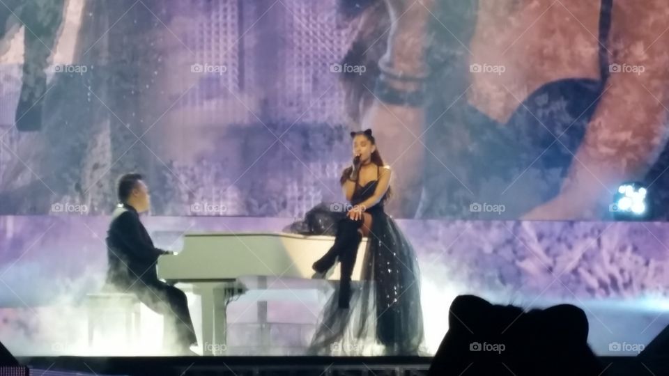 Ariana Grande. singing beautifully on a piano