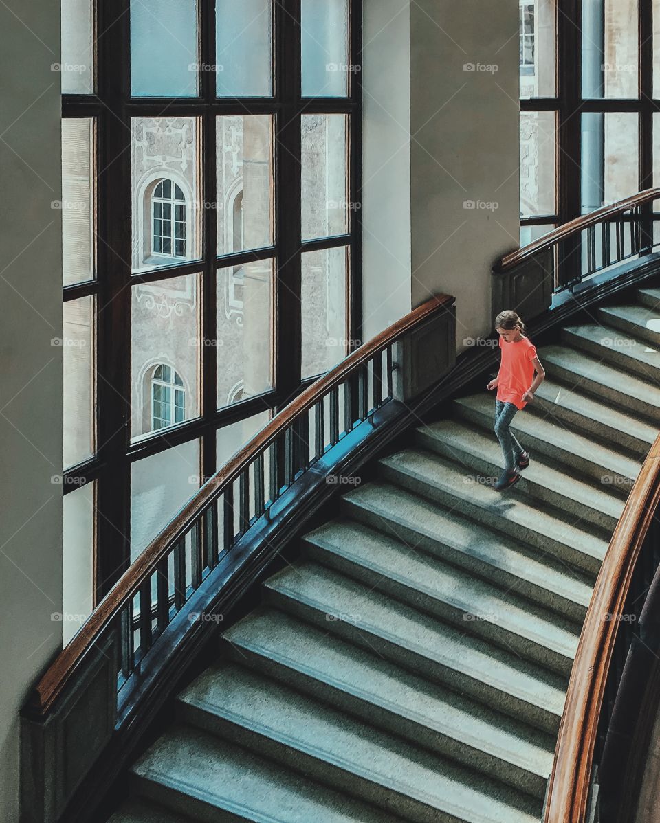 Teenage girl coming down on staircase