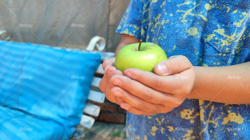 Child hands holding a apple