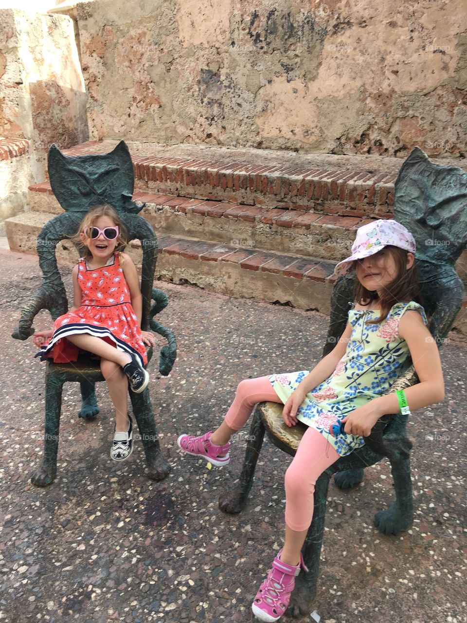 Two girls sitting in artistic cat chairs in Puerto Rico.