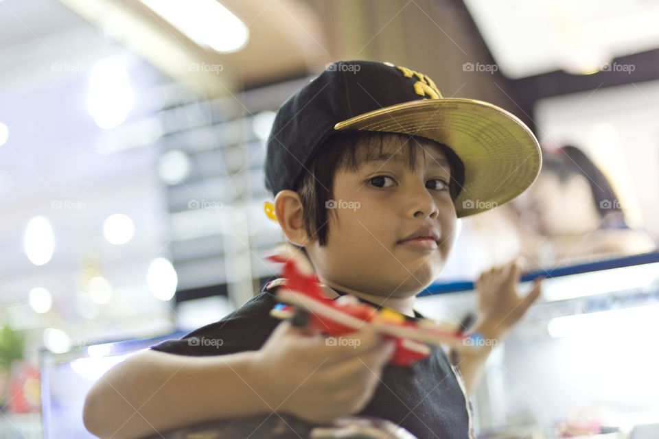 Portrait of a cute mixed race Asian boy. Thitiwin waiting at a shop counter