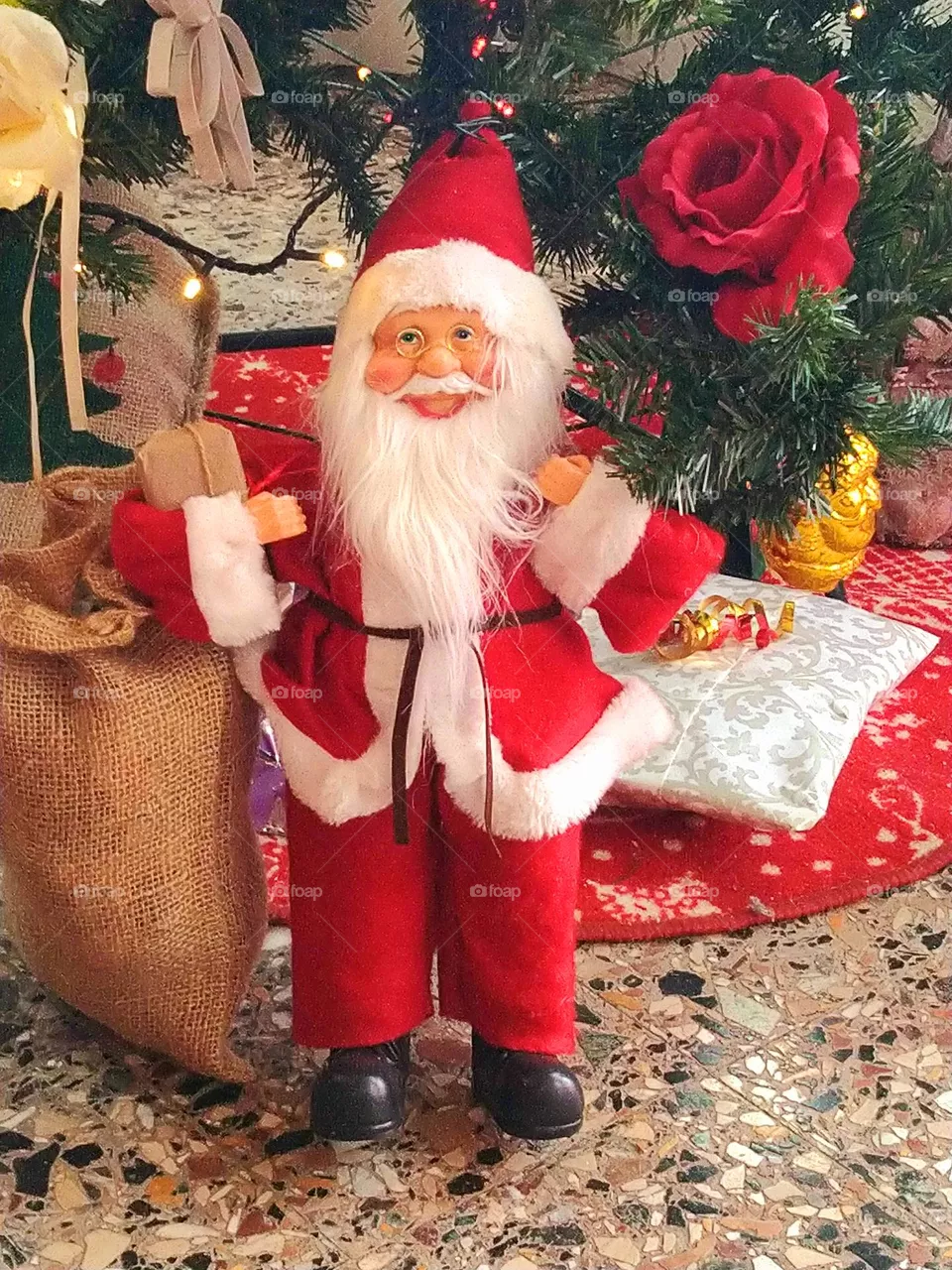 Santa Claus's puppet with the bag of presents under the Christmas tree