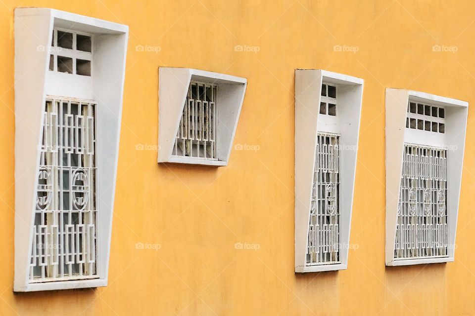 A house with white windows on yellow painted wall