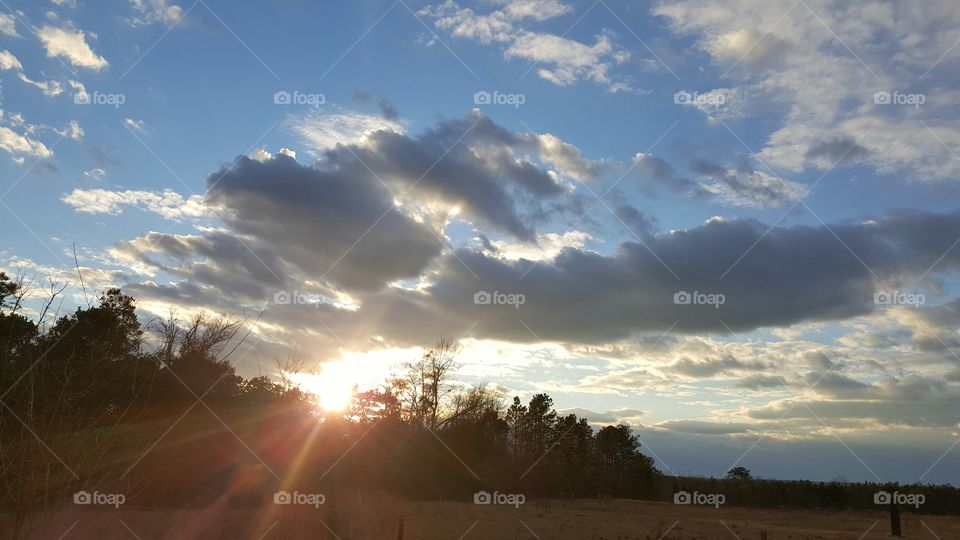 Blue sky, black cloud and golden rays
