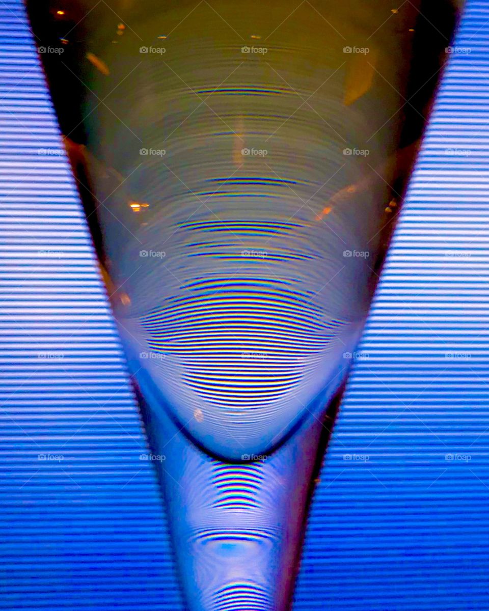 Champagne in glass bends light from screen