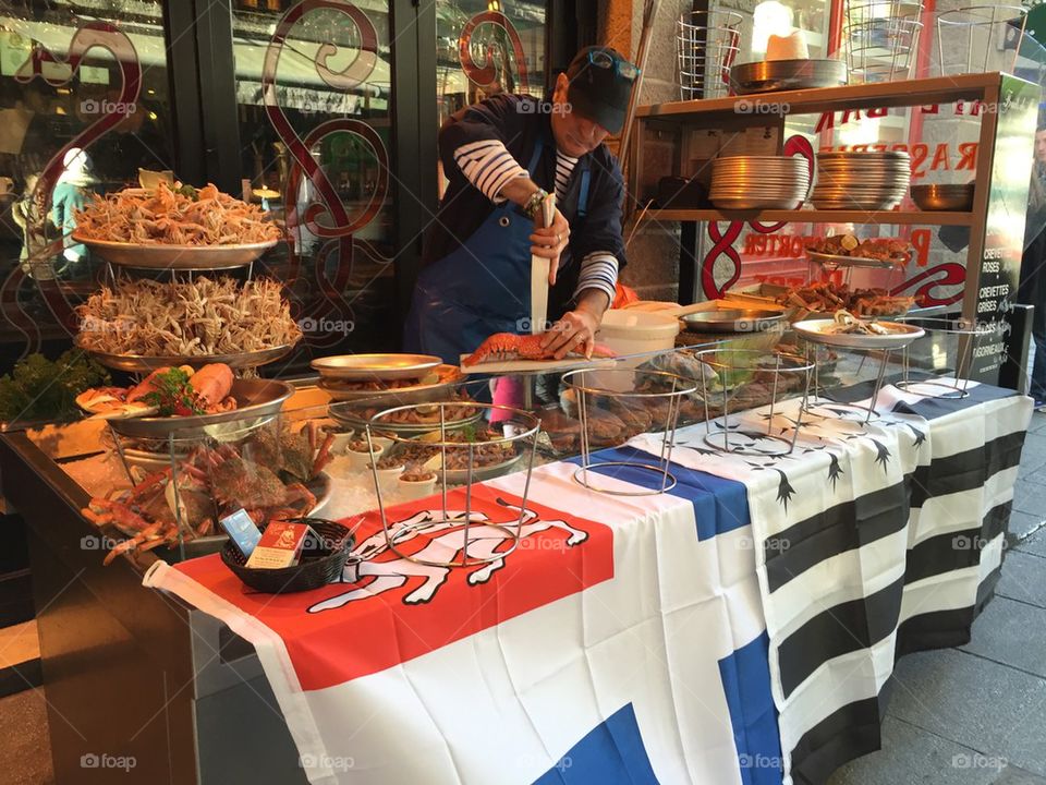 Seafood stall with man cutting lobster