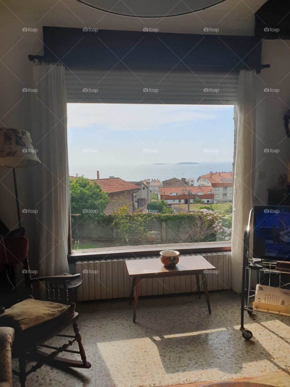 janela com casas e o mar.