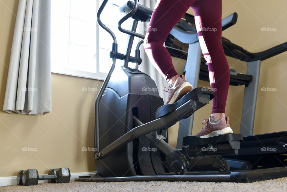 Woman's legs on an elliptical machine