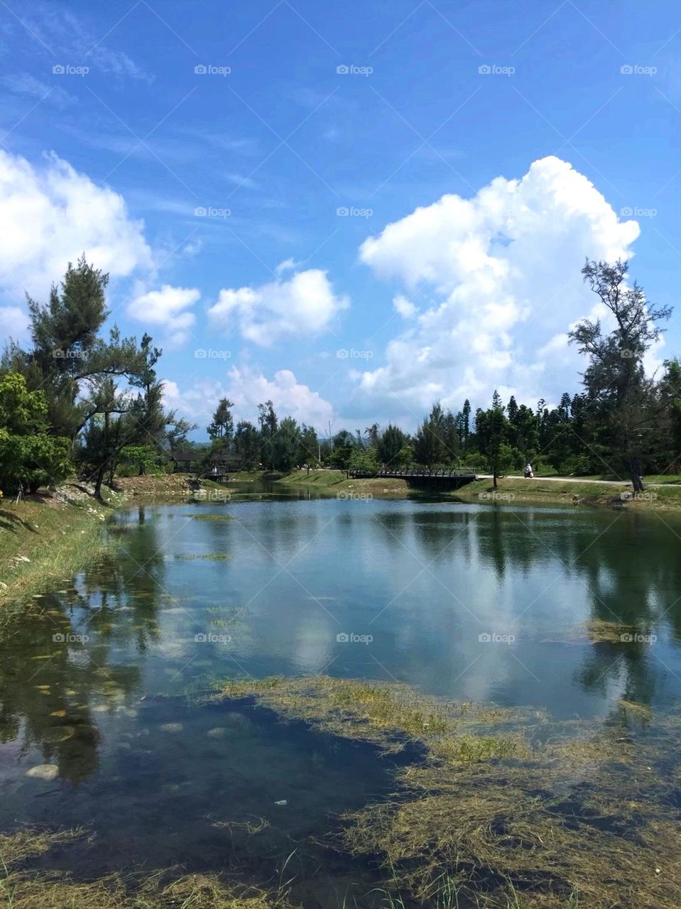 Blue sky, white clouds and lake water reflection