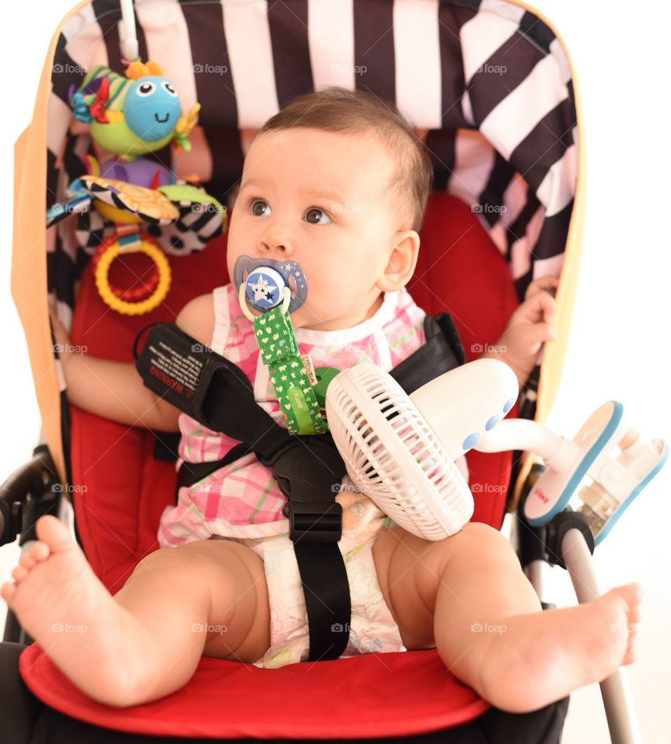 Baby girl playing in stroller