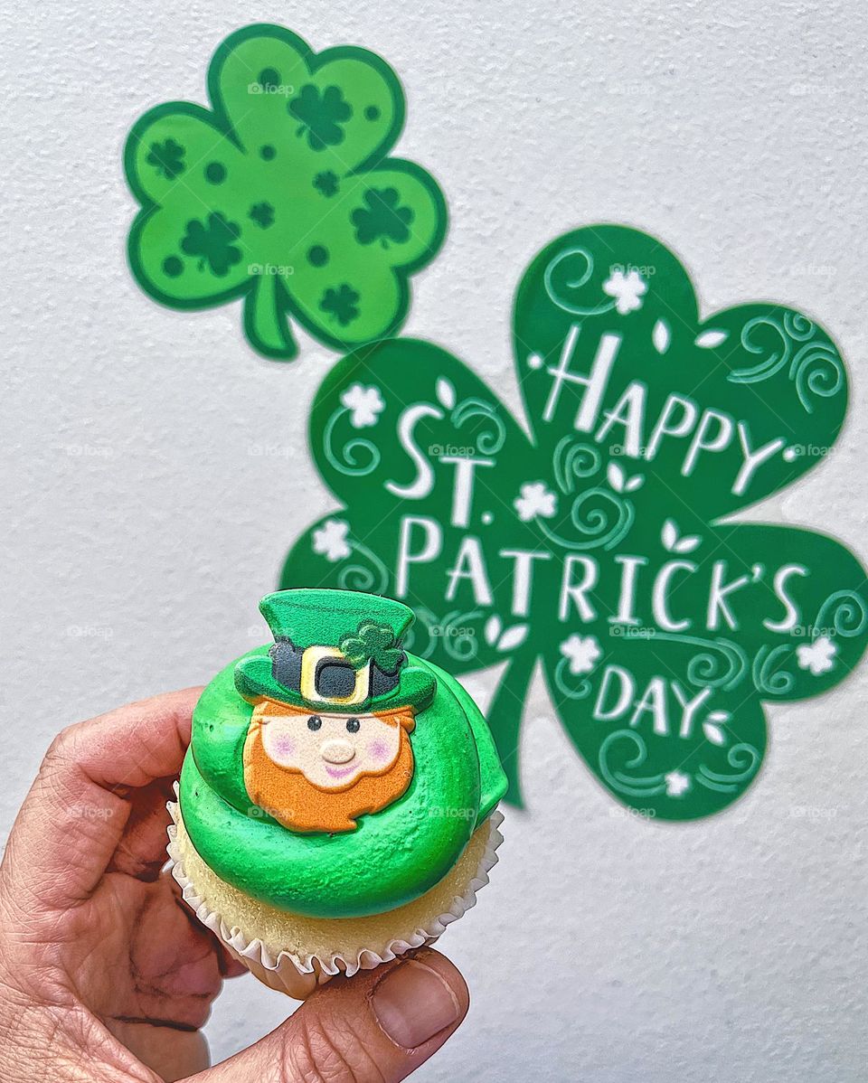 Eating a St. Patrick’s Day cupcake, celebrating St. Patrick’s Day, green surrounding a cupcake, delicious cupcake in woman’s hand, eating desserts first, smartphone food photography, mobile photography, woman’s hand holding a St. Patrick’s Day treat