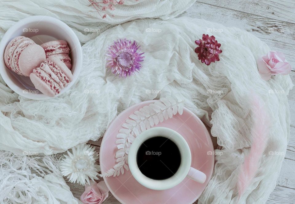Vintage feel pink and white flat lay with coffee and macaroons. 