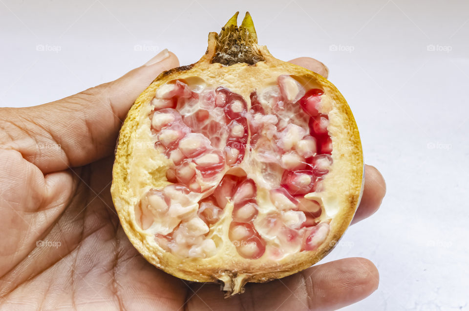 Half Of A Pomegranate In Hand