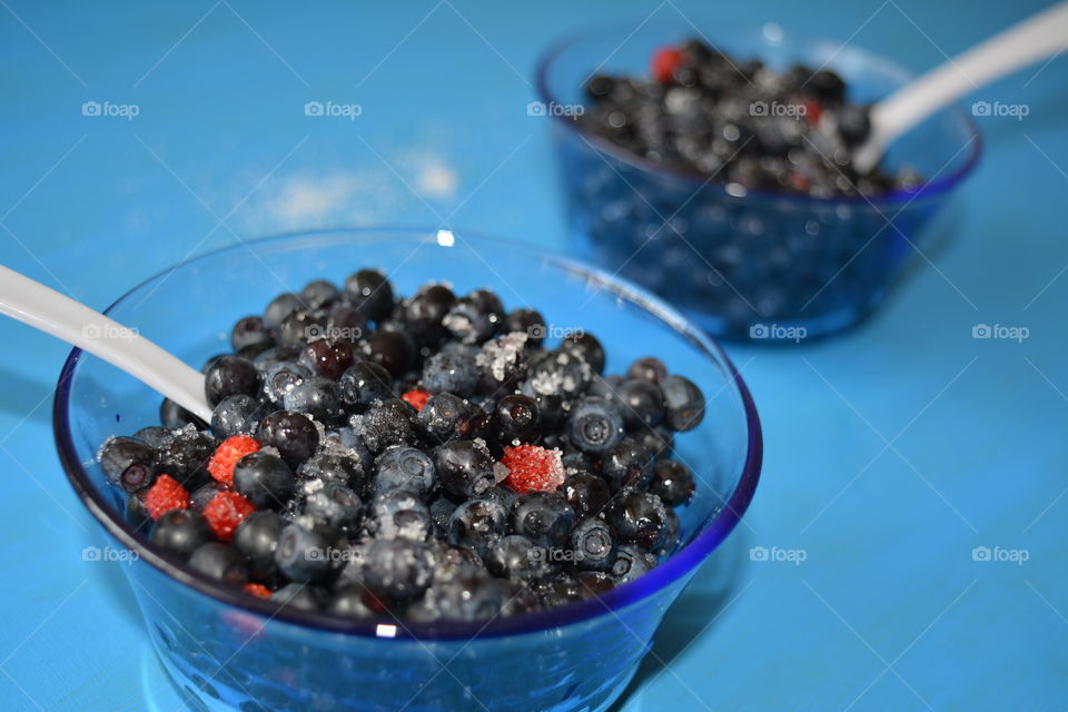 red blueberries summer food on a plate blue table background