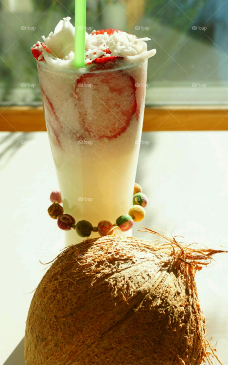 Fresh Fruit smoothie - Young Coconut smoothie topped with slices of strawberries and diced coconut meat