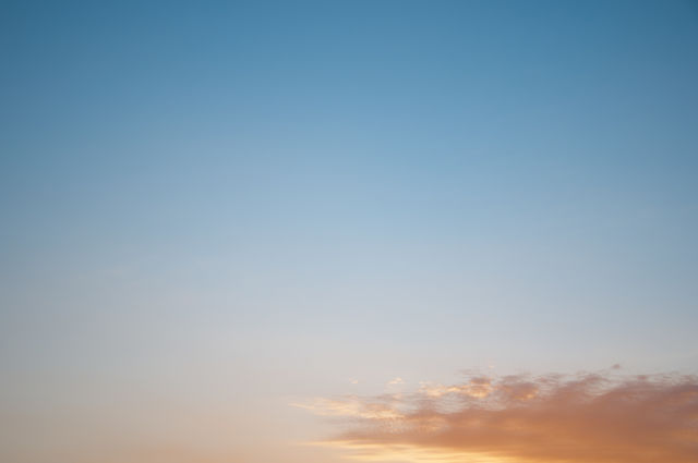 Small cloud in a blue sky at sunset