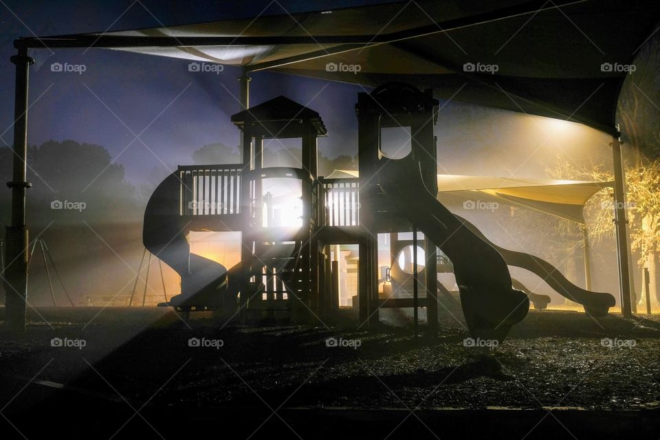 Foap, Day and Night: Scene at a playground well before daylight. Beams from the park lights pierce through the fog at Lake Benson Park in Garner North Carolina. 