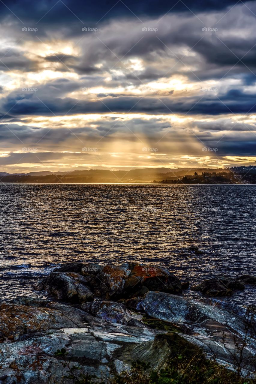 Sun beams through thick clouds on the Pacific Ocean coast 