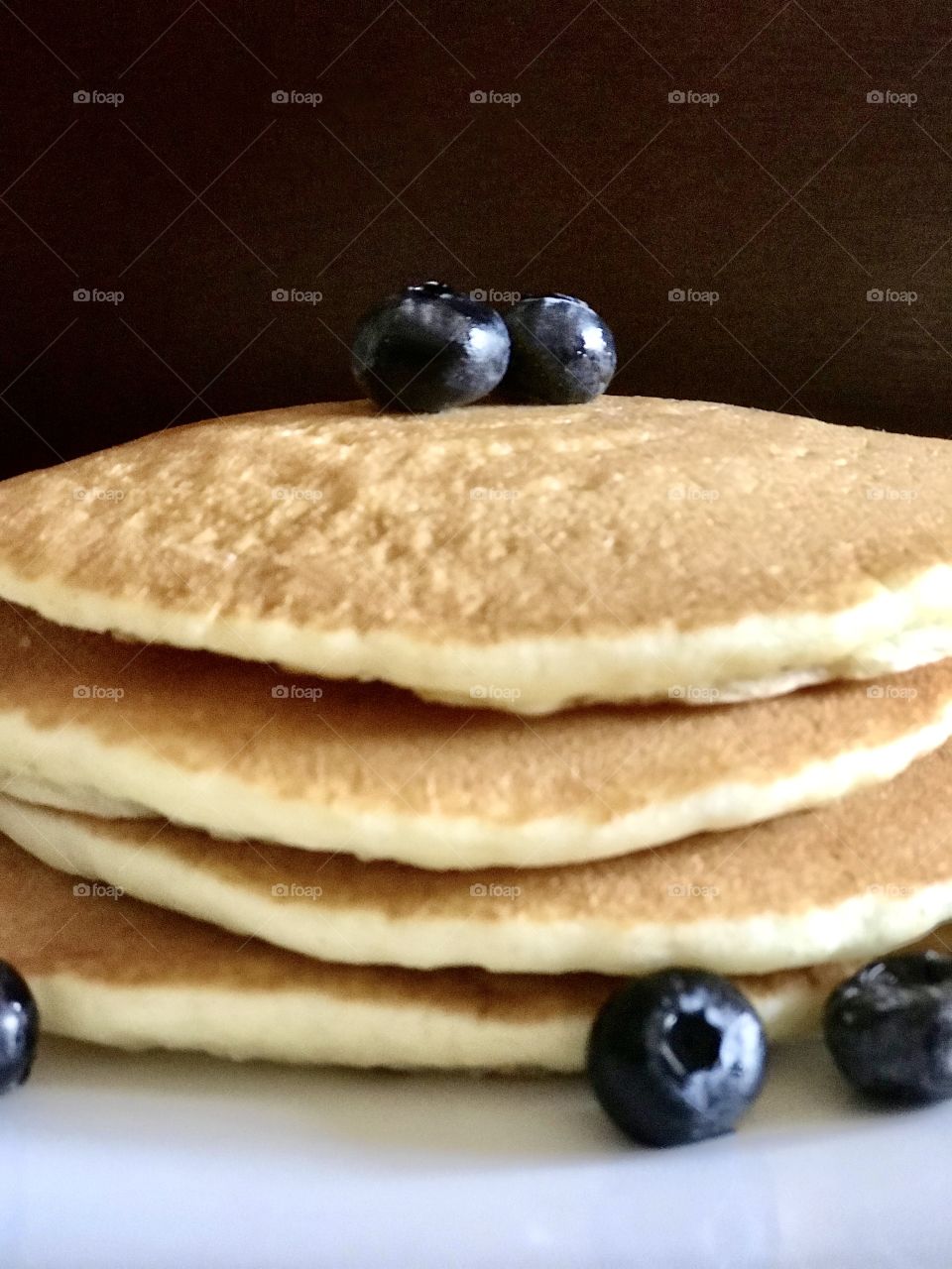 A stack of delicious golden pancakes with blueberries on top for breakfast 