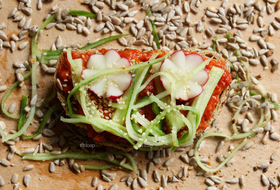 Home made sandwich with vegetables, radish, cucumber, tomato sauce, seeds