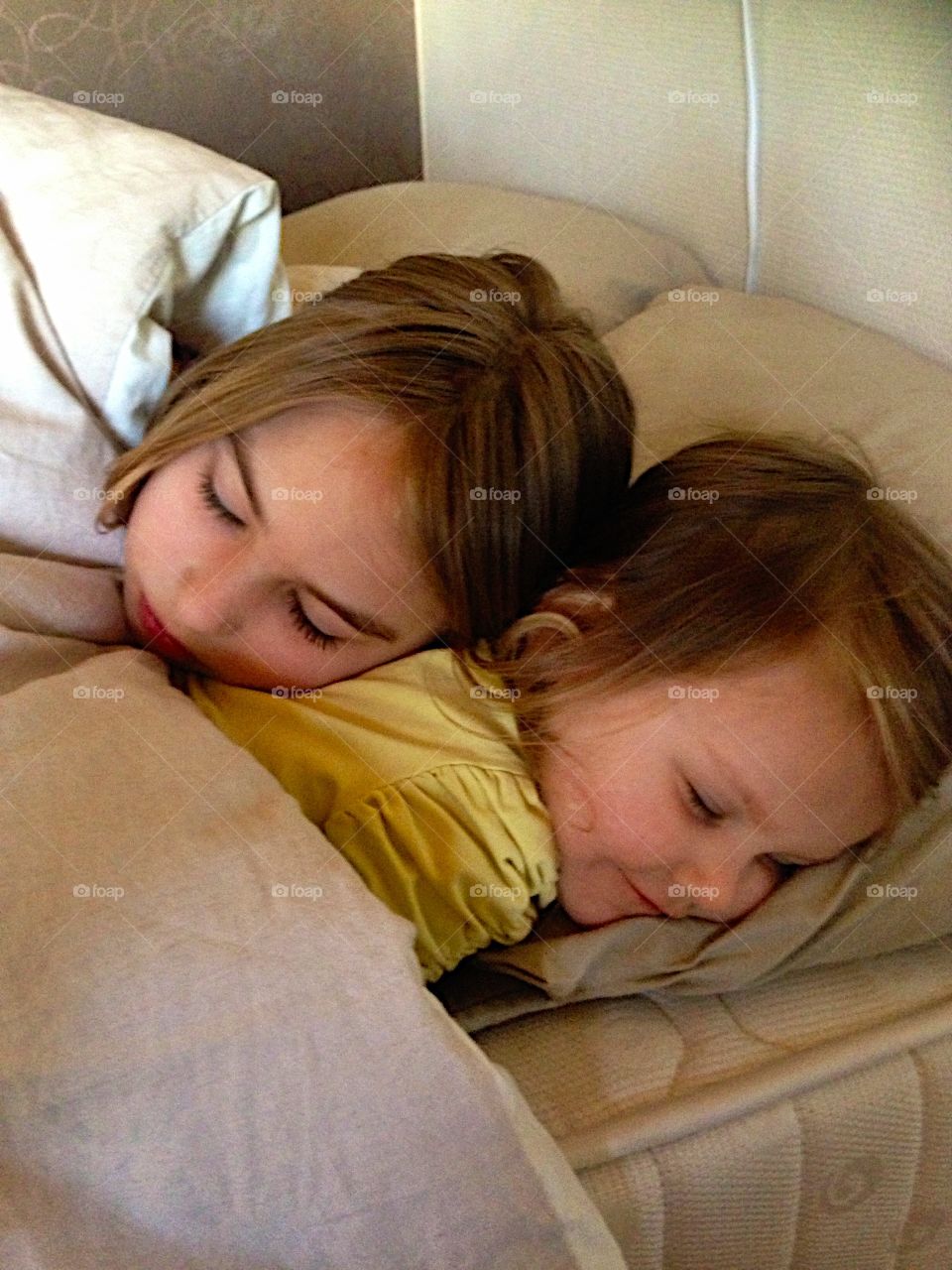 Close-up of sisters sleeping on bed