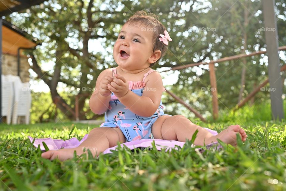 little girl playing with a leaf on the lawn