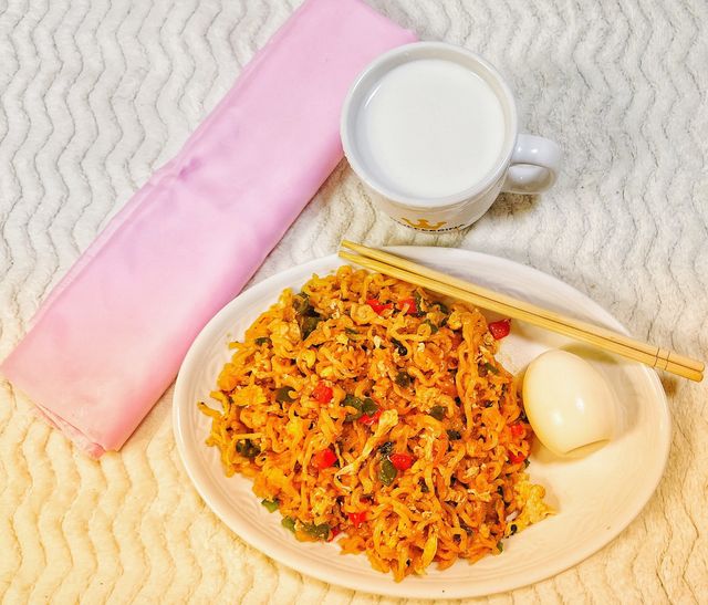 Noodles with egg and a cup of fresh milk