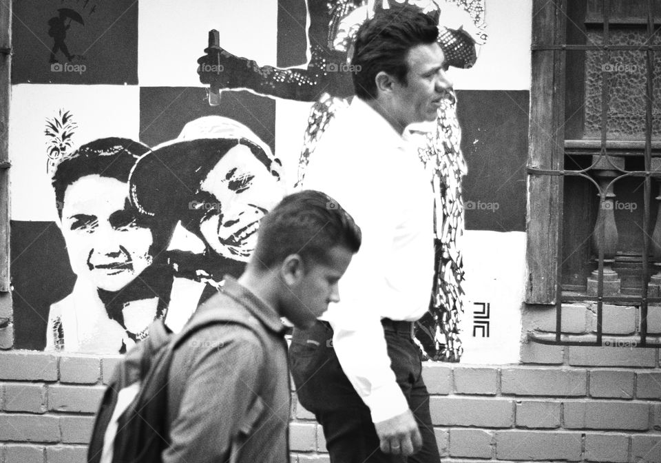 people walking in front of a graffiti