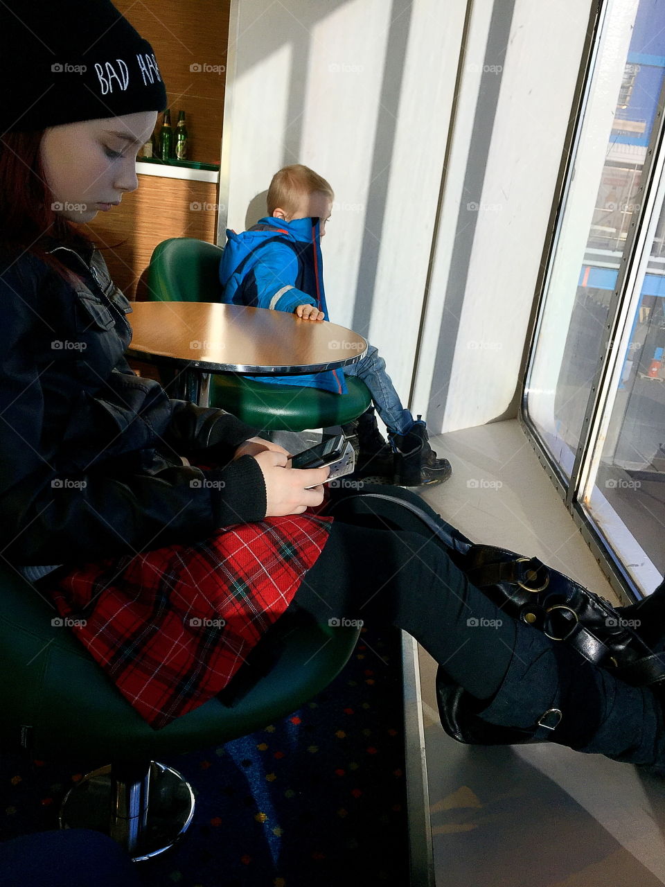 People traveling with a boat, a girl using her phone