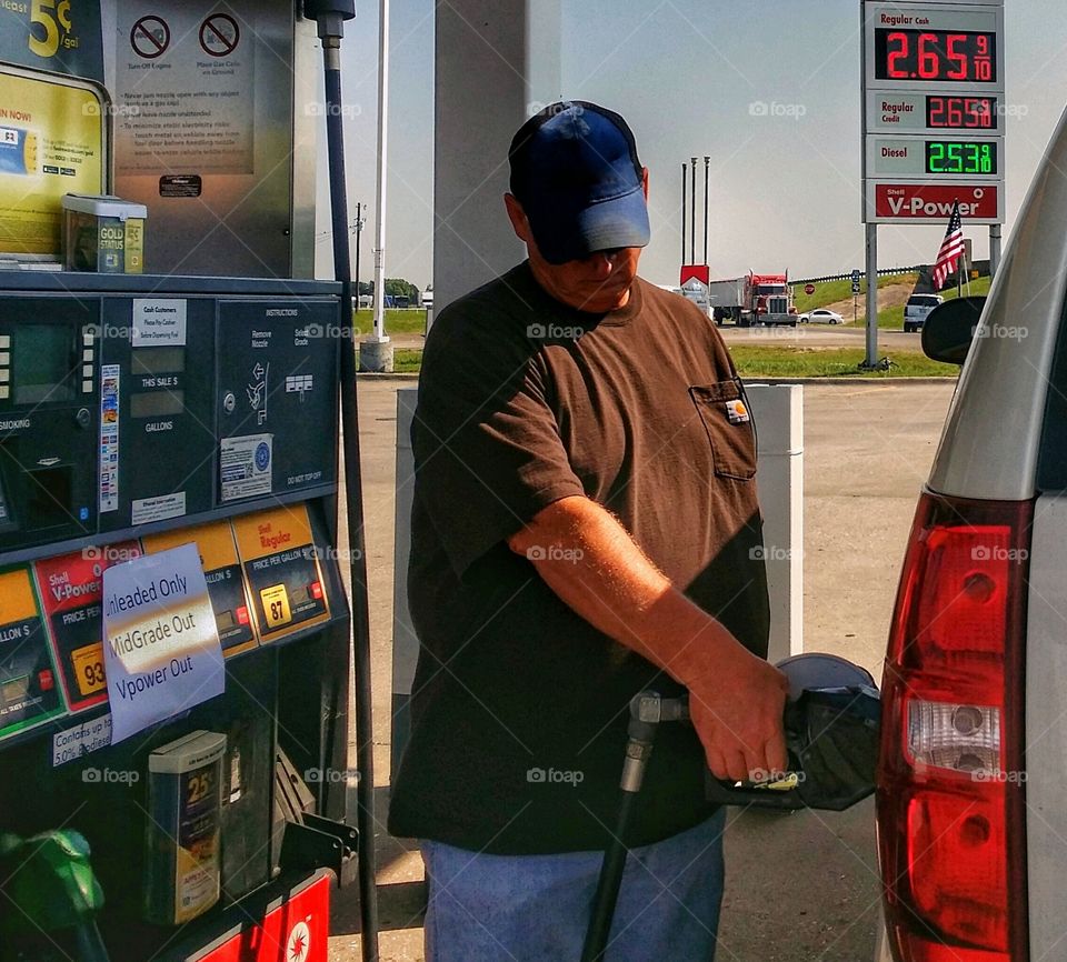 Petrol station worker filling petrol in car