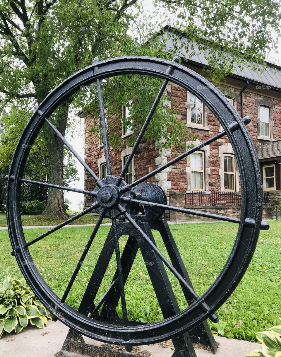 Ship’s wheel or helm in front of an old building