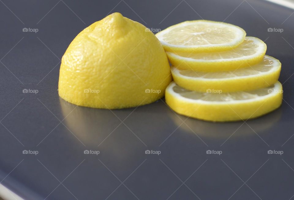 Illuminatingly Fresh; Fresh, Half sliced lemon on a grey tray 