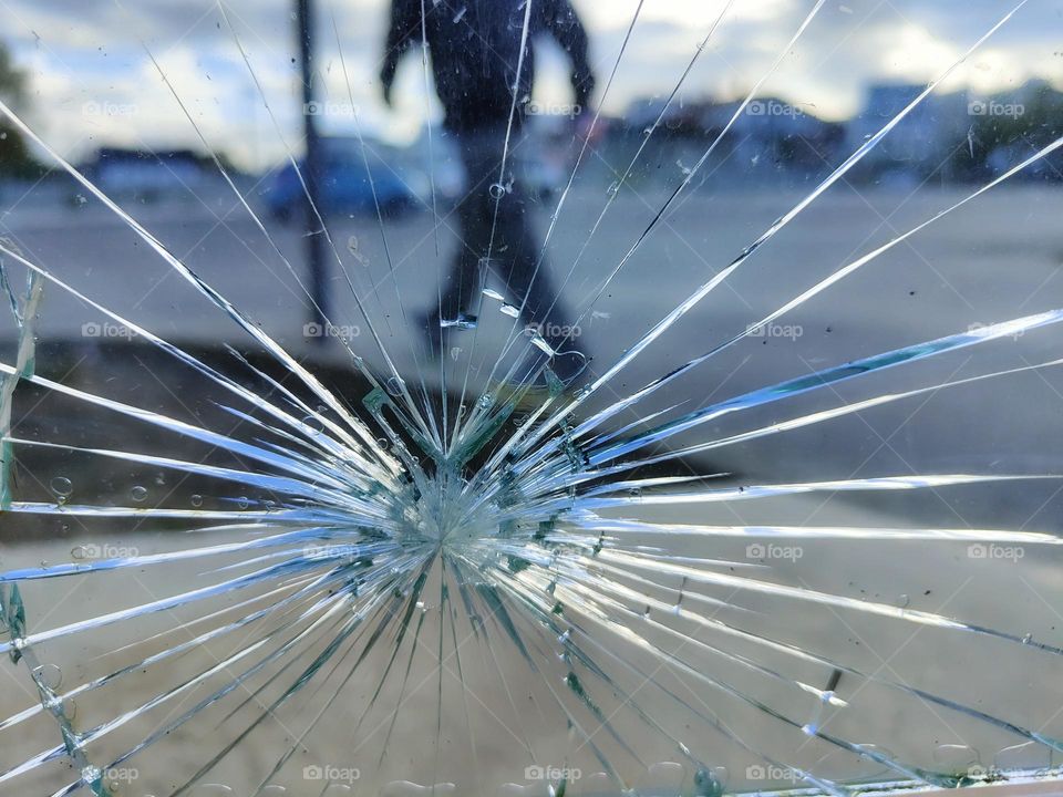 conceptual photo of a hooligan who runs away after damaging the windshield of a car